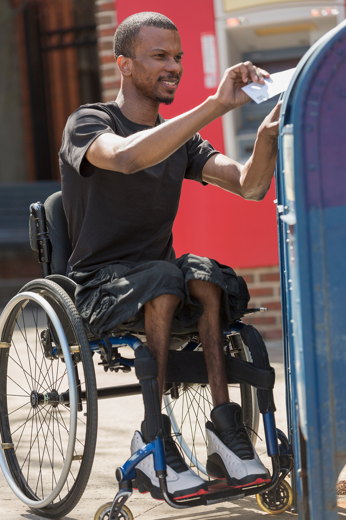 A person in a wheelchair voting by mail.