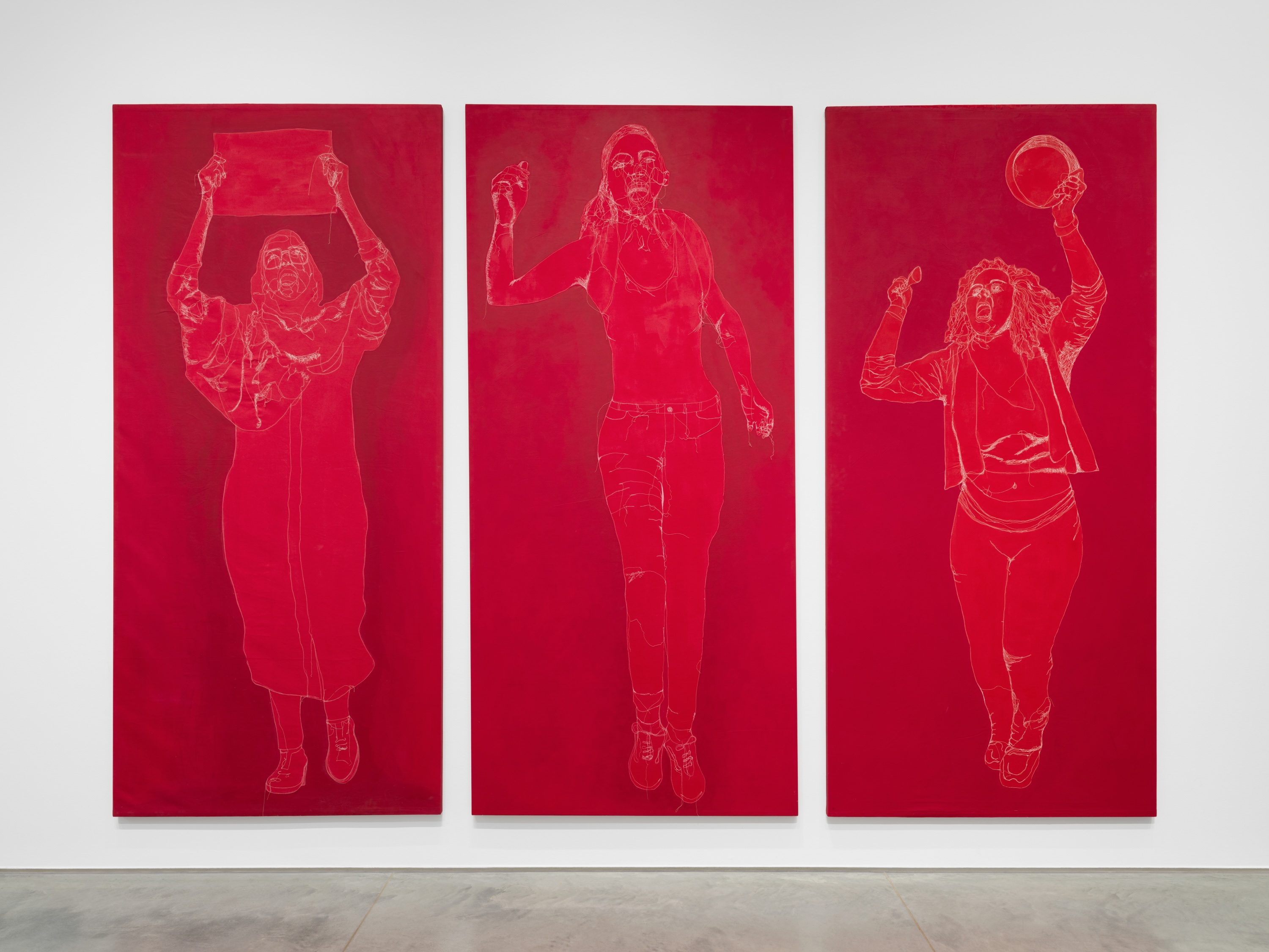 Three red tapestries with white details featuring silhouettes of women protesters.