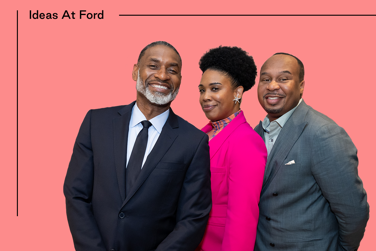 Three people pose against a salmon background with the text "Ideas at Ford." The first person on the left, Charles Blow, is dressed in a suit. The second person, Joyelle Nicole Johnson, in the middle, is wearing a pink blazer, and the third person, Roy Wood Jr., on the right, is wearing a gray suit.