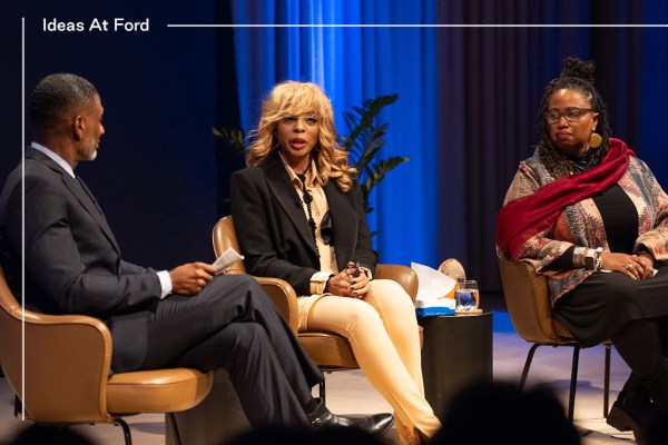 Three people are sitting in conversation against a blue curtain background: from left to right they are Charles Blow in a dark suit and tie, Stephanie “Sparkle” Edwards, in a black blazer and beige top and slacks and Aishah Shahidah Simmons in a patterned jacket, black top and slacks and a maroon scarf.