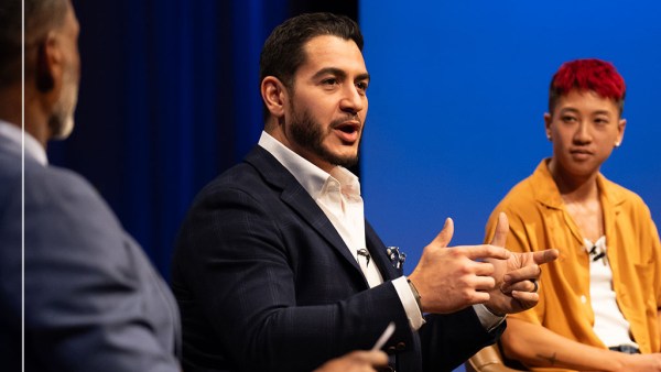 Three people are sitting in conversation against a blue curtain background. From left to right, they are Charles Blow in a blue suit, Dr. Abdul El-Sayed, who has a beard and wears a dark suit with a white collar shirt, and Jes Tom, who has short hair and wears a brown shirt.